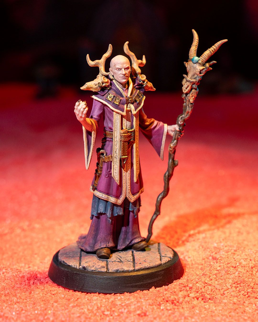 Painted Human Warlock miniature in dark arcane robes, holding a twisted horned staff with glowing eldritch detail. | Helios Tabletop