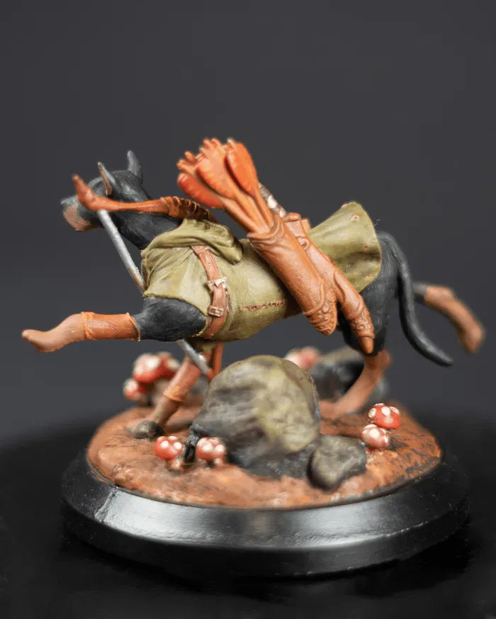 Back view of painted Miniature figurine of a dog dressed like an archer. It has a long quiver and bow around its back