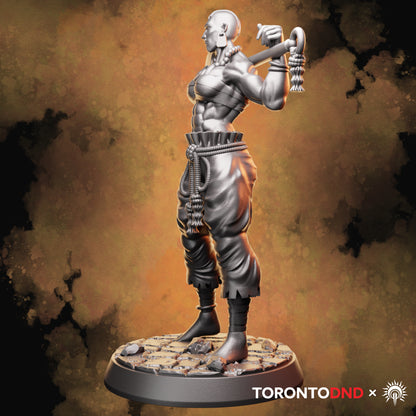 Right side view of a Goliath Barbarian miniature highlighting braided cords, layered clothing, and the axe haft detail