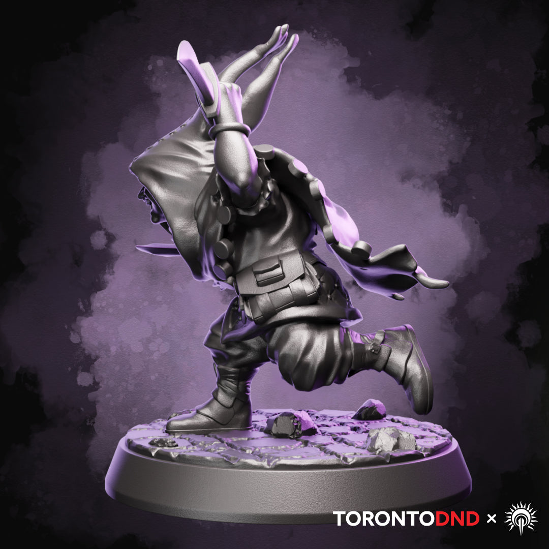 Left side view of a high-quality resin Halfling Rogue miniature highlighting motion, cloak movement, and forward momentum