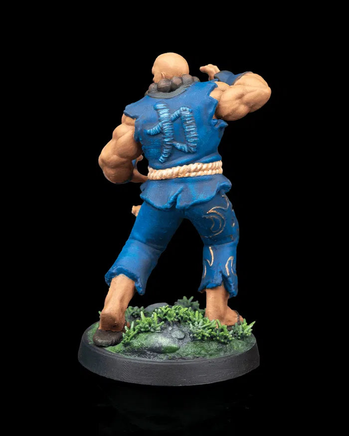 Back view of the painted Human Monk Stonefist miniature, showing the stitched symbol on his gi and the textured rocks and foliage on the base.
