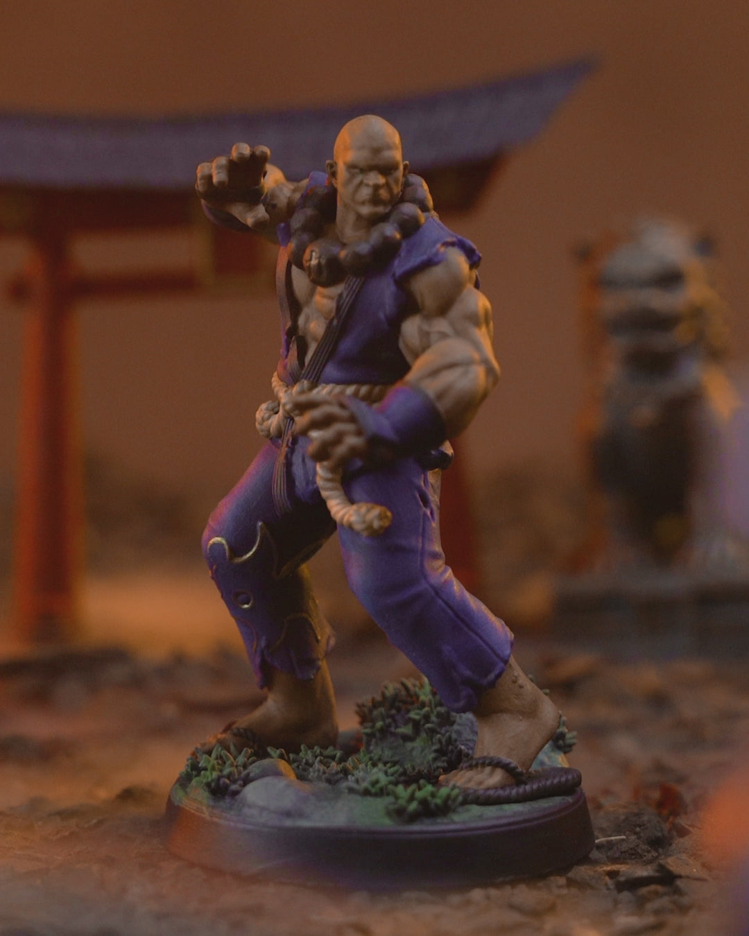 360 degree turntable video of the painted Human Monk Stonefist miniature, rotating to show his blue gi, rope belt, beads, and scenic base from every angle.